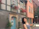 Smiling young woman standing in front of a cozy German apartment building.