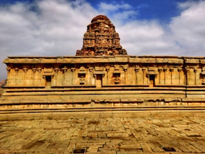 Ancient temple carved in stone with intricate sculptures under a bright sky.