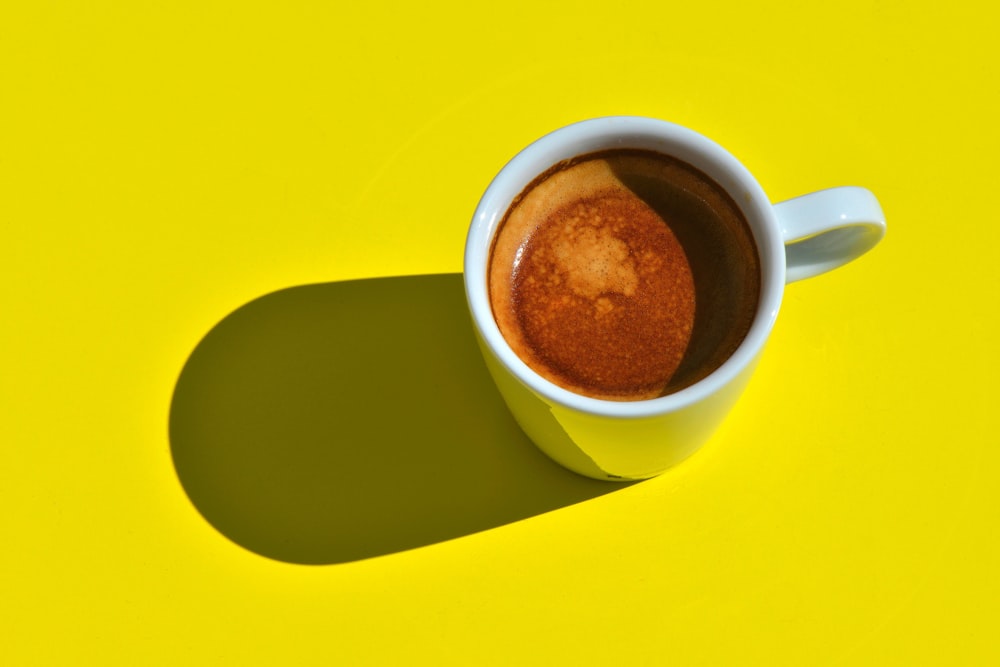 white ceramic mug with brown liquid