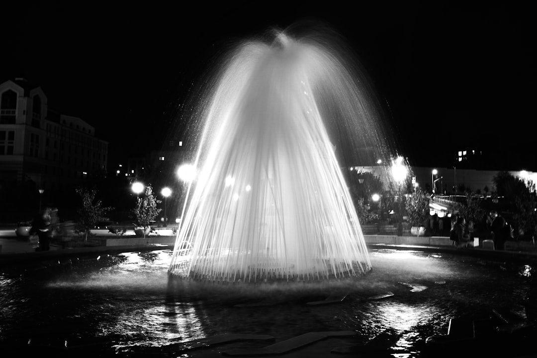 water fountain in the middle of the road during night time