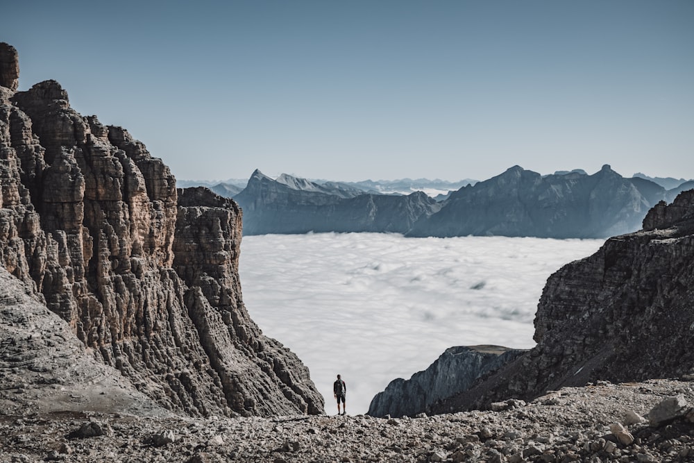 person standing on rocky mountain during daytime