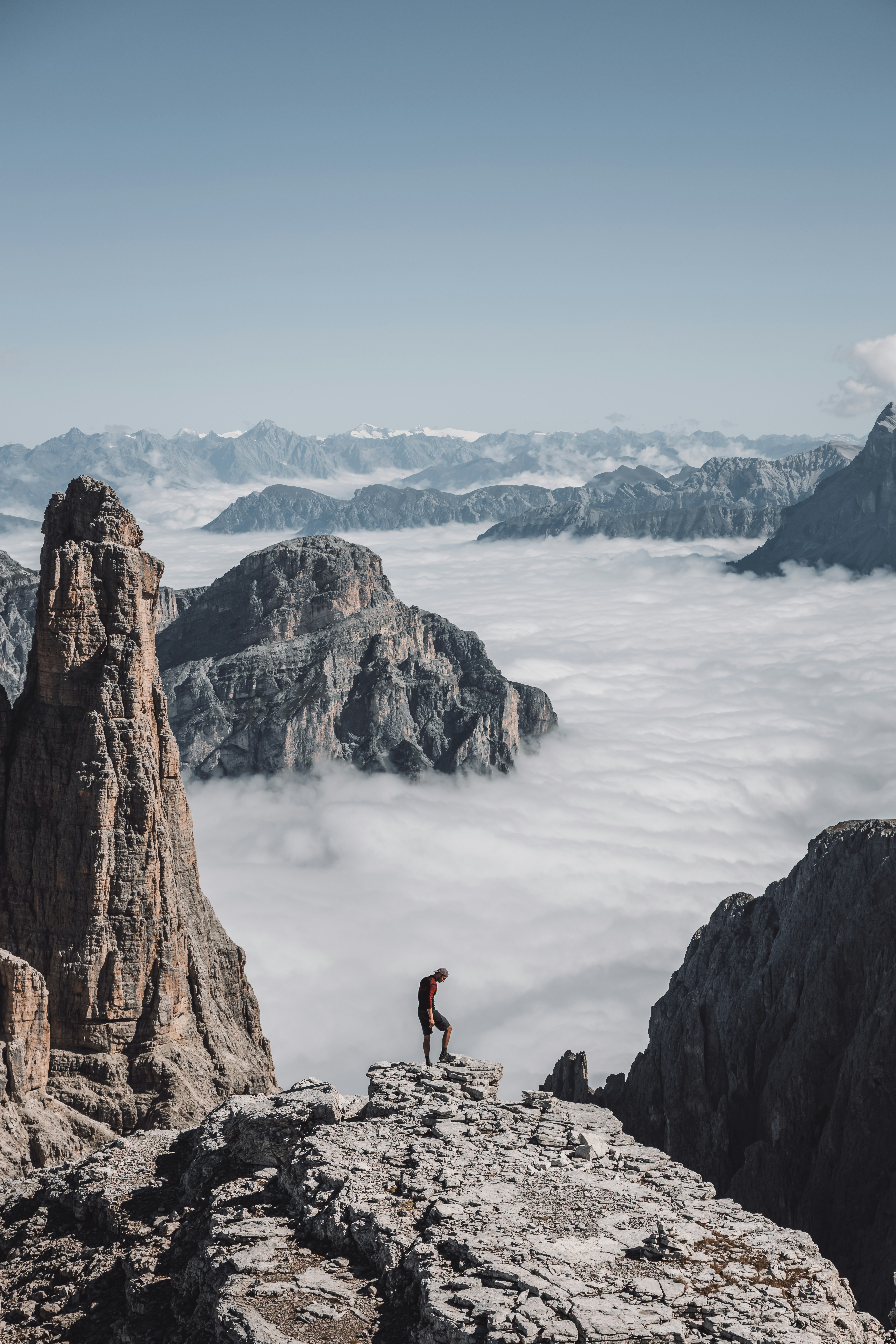 people on brown rock formation near body of water during daytime