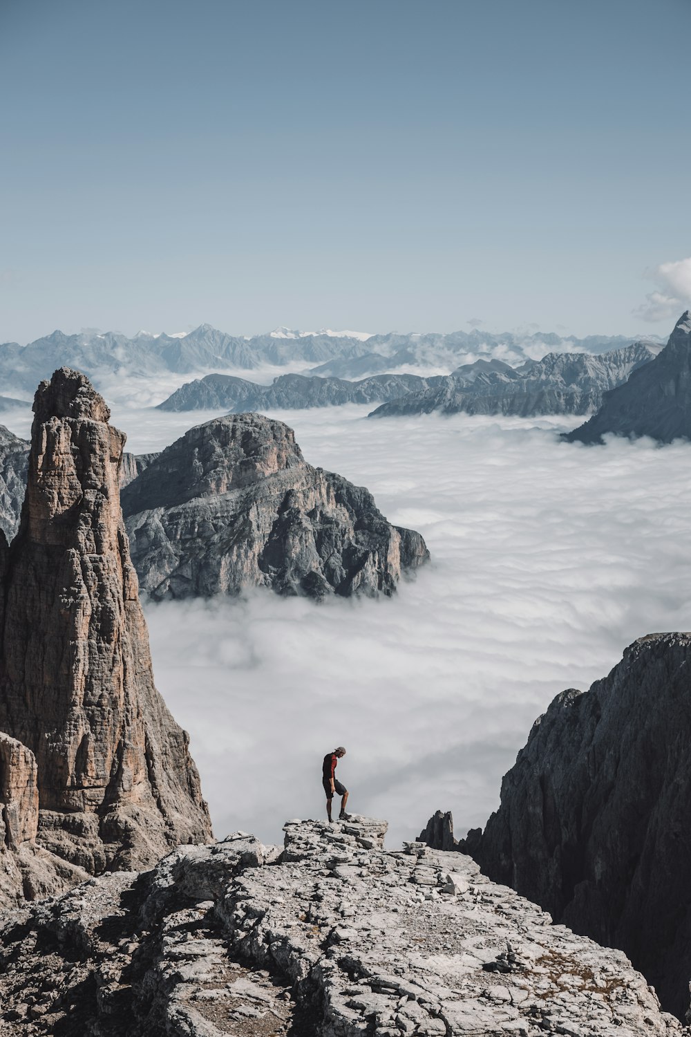 people on brown rock formation near body of water during daytime