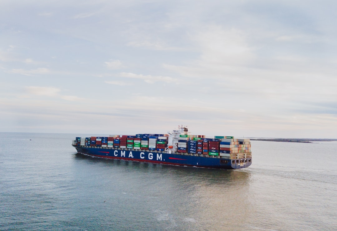 a large container ship sailing across a body of water, Off shore cargo