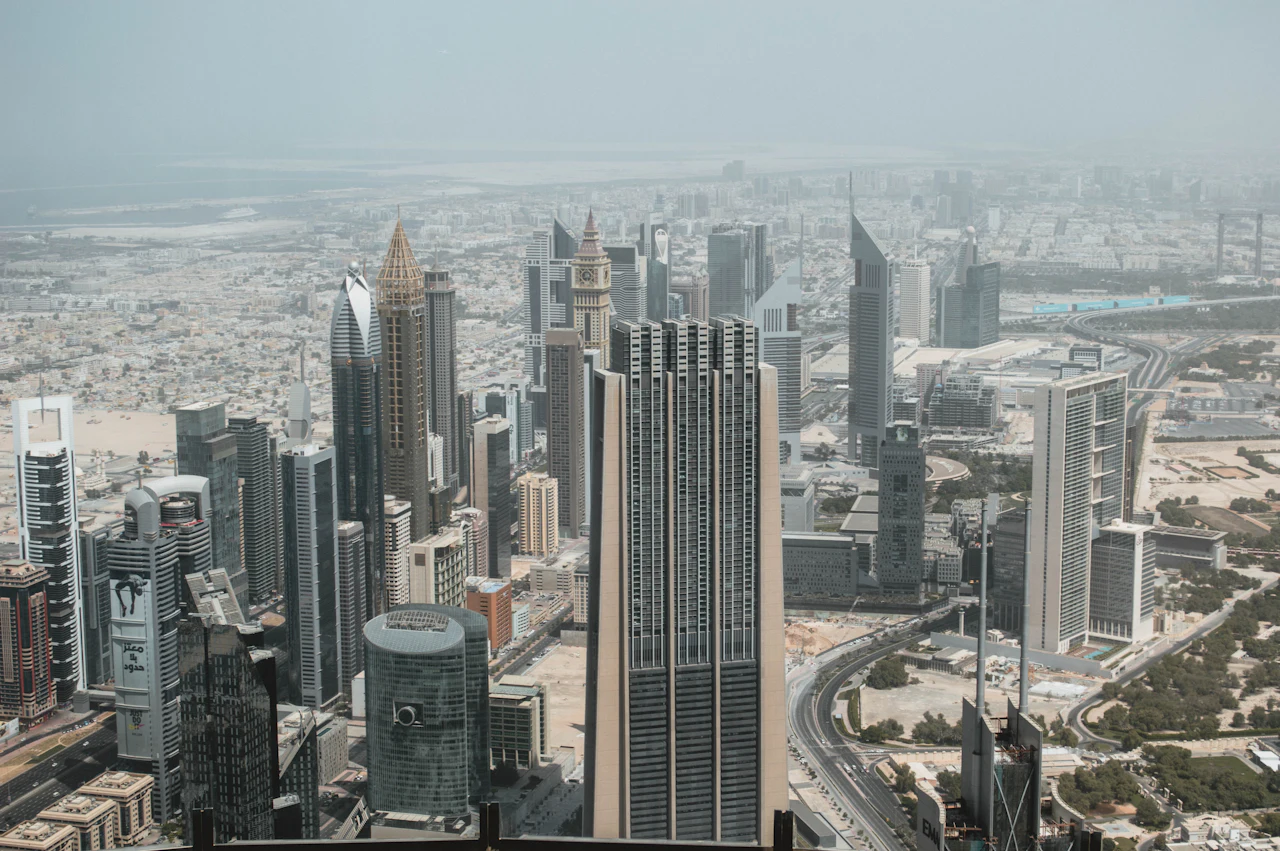 Downtown Dubai's towers and the city beyond, seen from Burj Khalifa on a hazy day