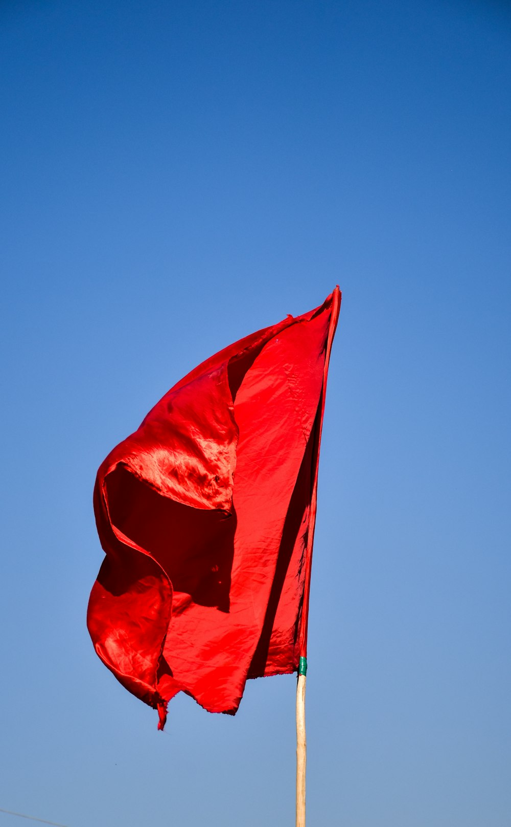 Bandera roja bajo el cielo azul durante el día