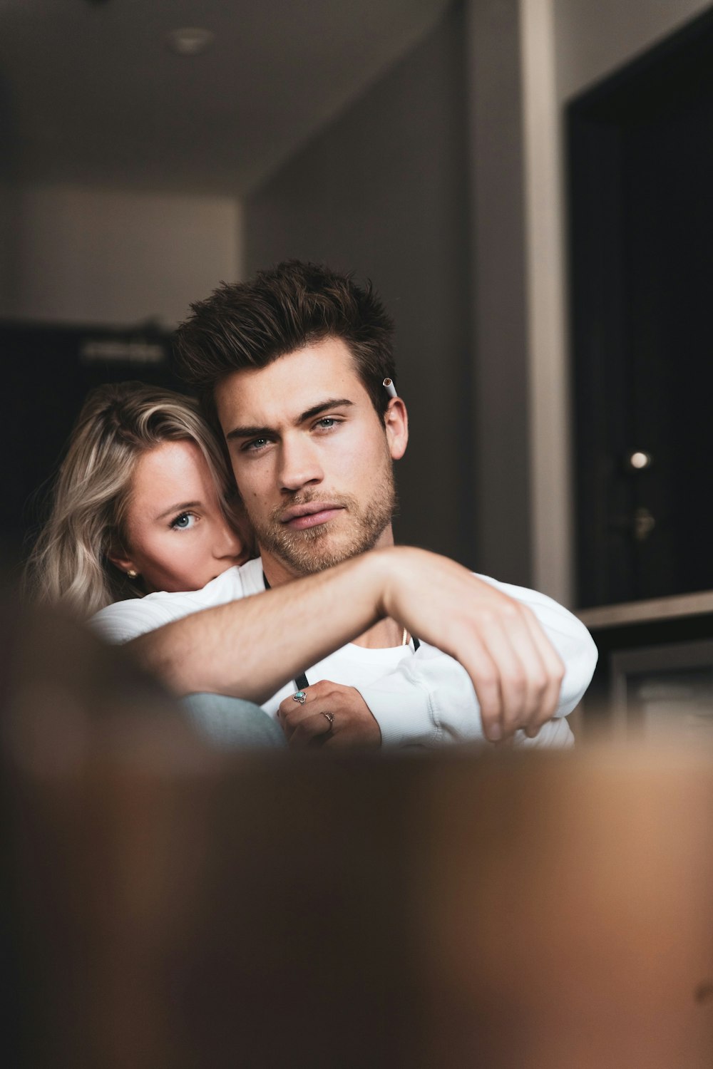 man in white tank top hugging woman in white tank top