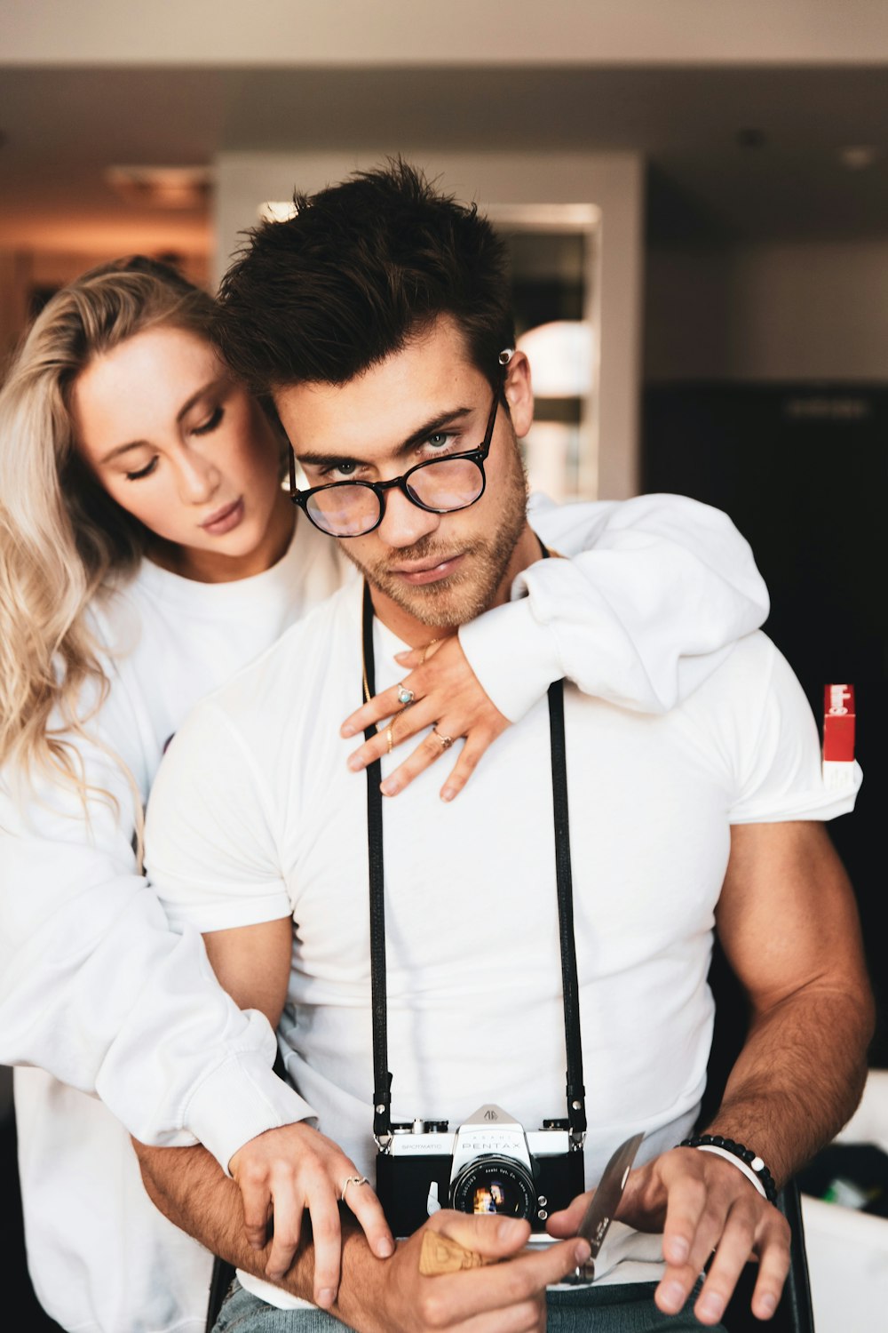 woman in white button up shirt holding black smartphone