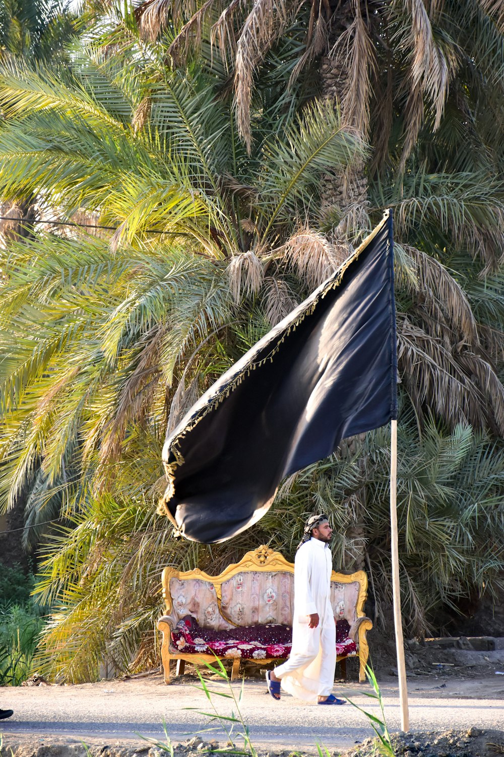 woman in white dress standing near blue flag