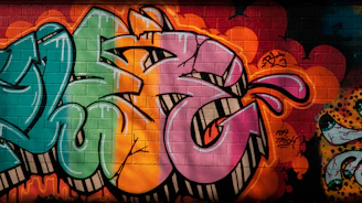 A vibrant t-shirt featuring an artistic urban design displayed on a concrete wall background.