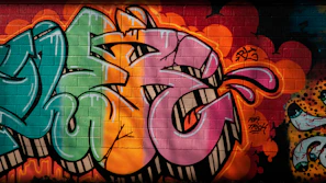 A vibrant t-shirt featuring an artistic urban design displayed on a concrete wall background.