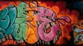 Vibrant graffiti on a brick wall featuring large, stylized letters in shades of pink, green, and orange. The artwork includes dynamic shapes and bold outlines, accompanied by expressive splashes and dots in varying colors. The vivid background is layered with multiple colors and spray paint textures, contributing to the urban and artistic atmosphere.