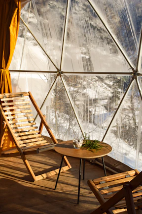 Interior view of a cozy wooden dome with minimalist furniture and natural light.