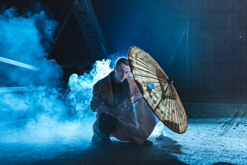 man in black jacket holding brown and black hand fan