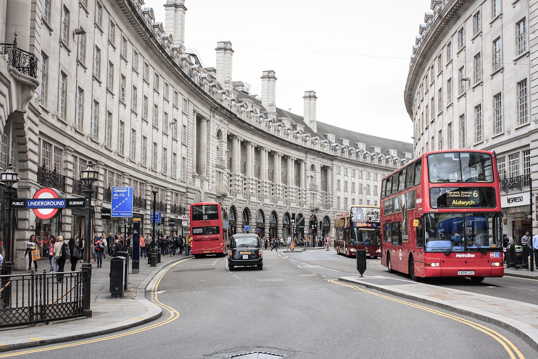 red double decker bus on road near building during daytime