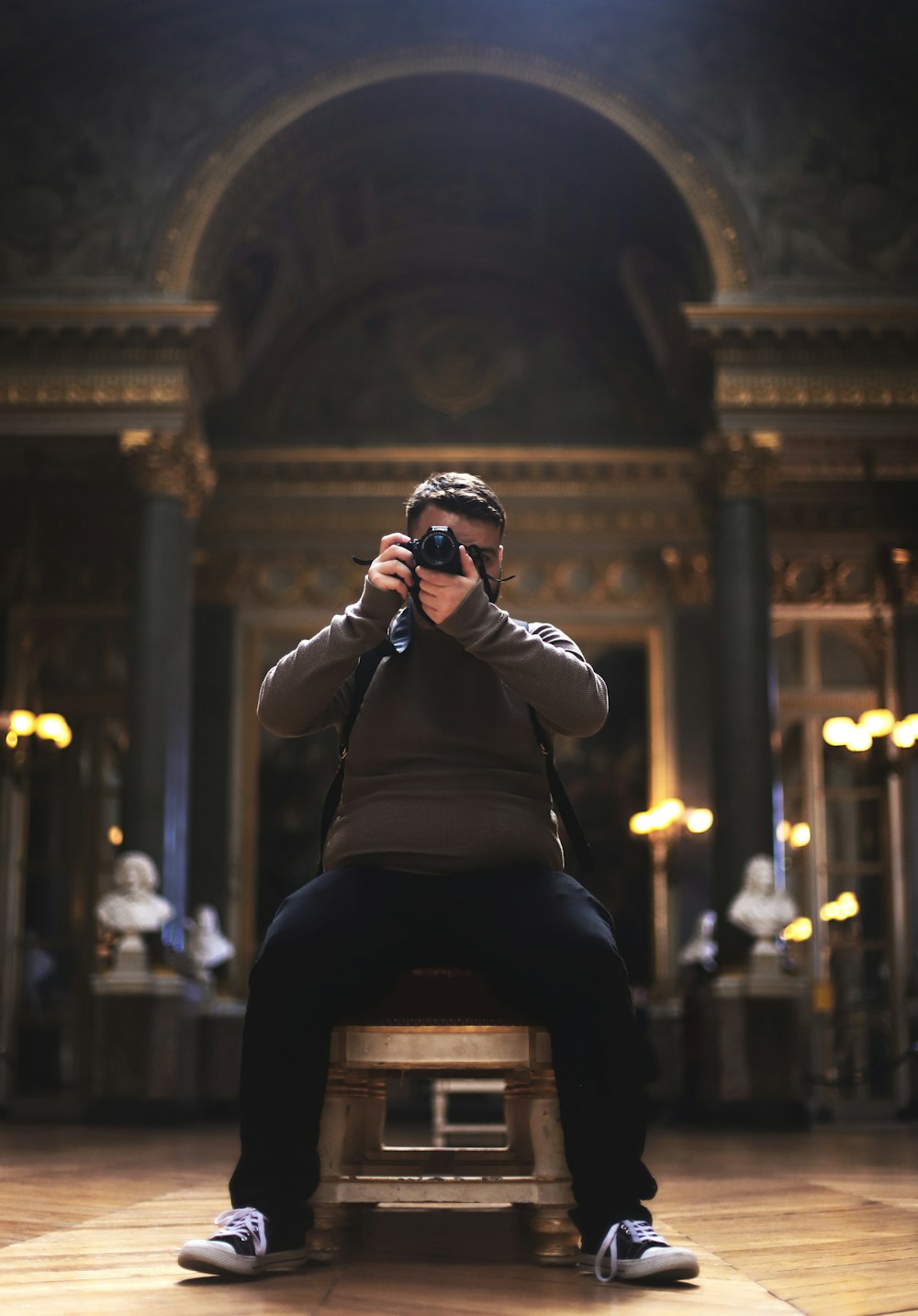 woman in black long sleeve shirt taking photo of building during night time