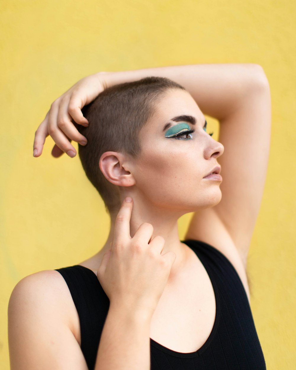 woman in black tank top with blue eye shadow