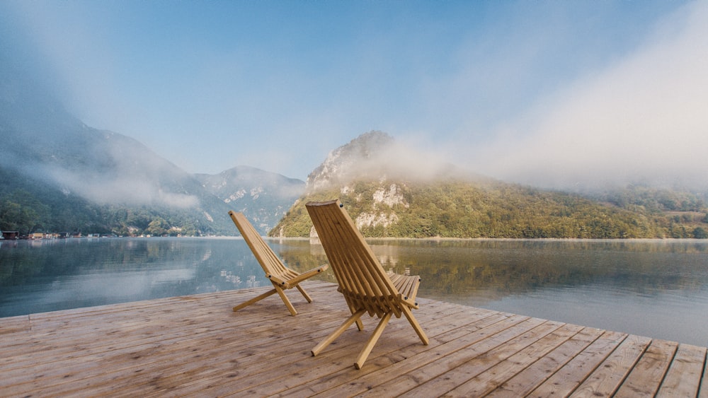 sedia di legno marrone sul molo vicino al lago durante il giorno