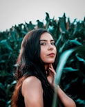 woman in black tank top standing beside green plant