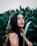 woman in black tank top standing beside green plant