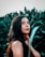 woman in black tank top standing beside green plant