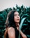 woman in black tank top standing beside green plant