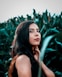 woman in black tank top standing beside green plant