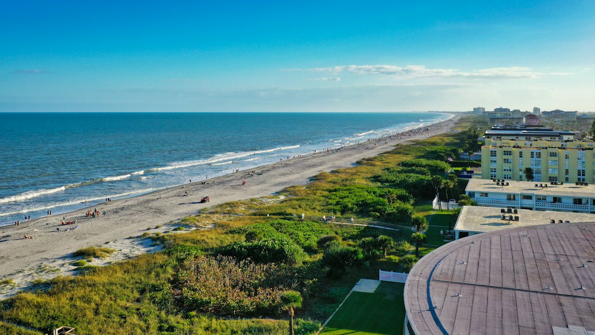 A wide beach with dunes and low-rise condos along the Gulf