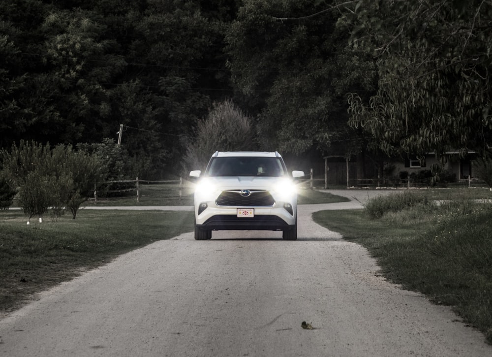 white car on gray asphalt road during daytime