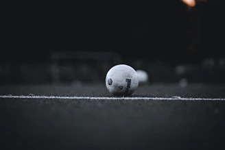 A minimalist dark-themed graphic showing a football pitch with tactical data overlays.
