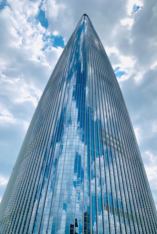blue and white glass walled high rise building under white clouds and blue sky during daytime in Lotte World Tower South Korea