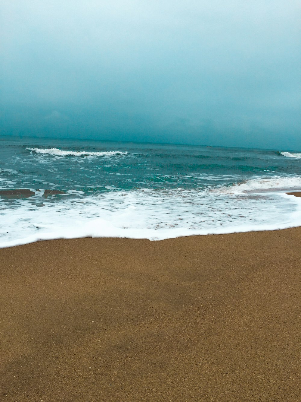 sea waves crashing on shore during daytime