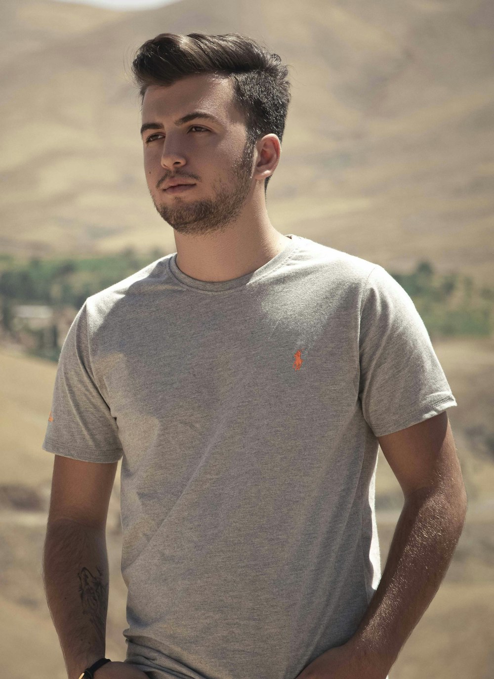 man in grey crew neck t-shirt standing on field during daytime