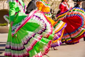 Traditional dancers performing in bright costumes during the Guelaguetza festival.