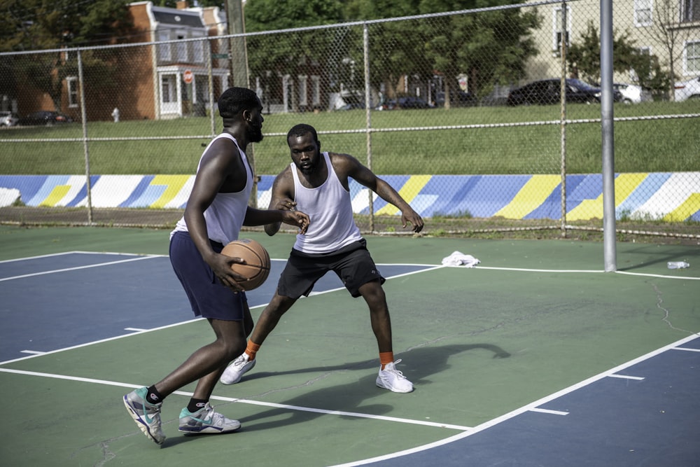 man in white tank top playing basketball