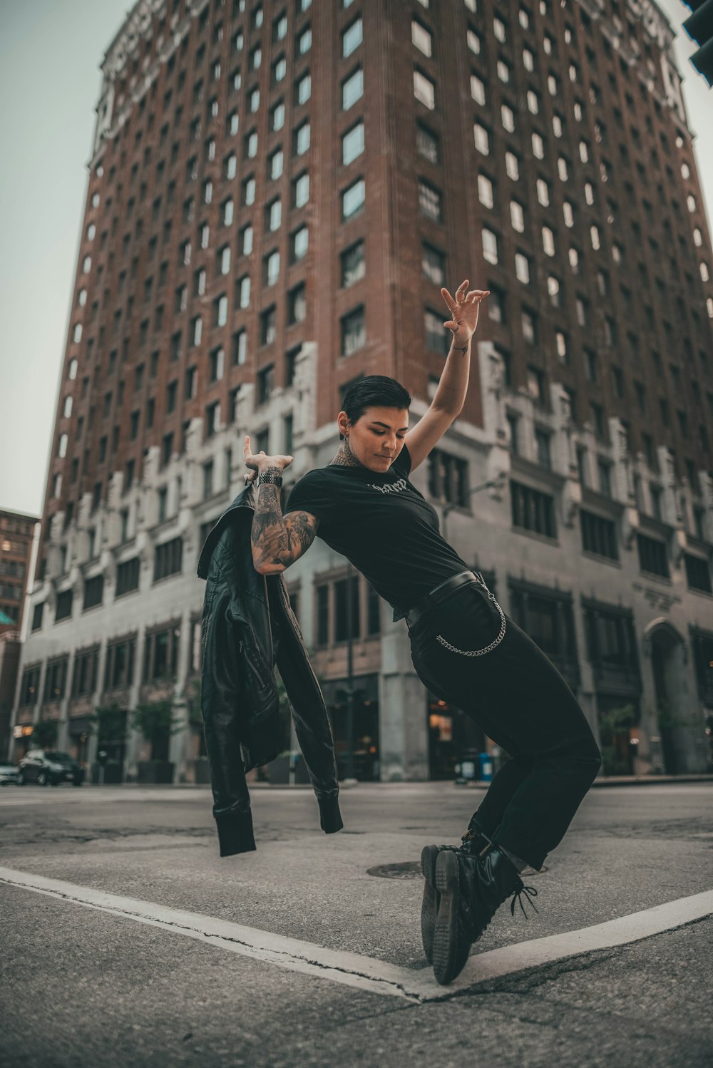 man in black t-shirt and black pants jumping on gray concrete floor during daytime