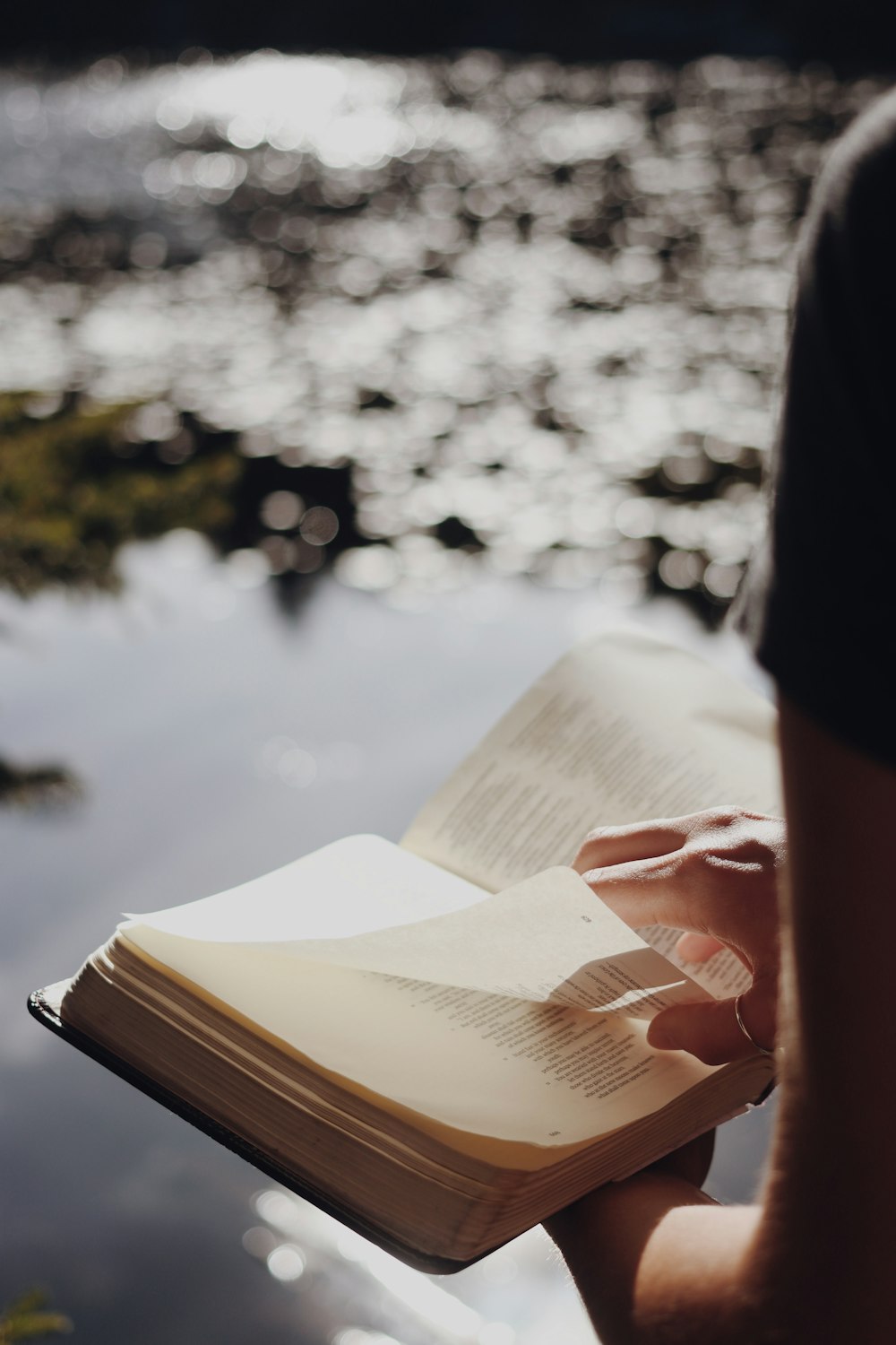 person in black long sleeve shirt holding book