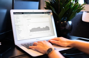 person using macbook air on brown wooden table