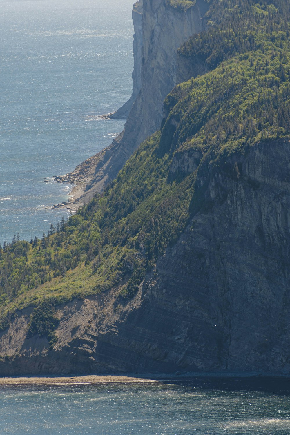 green and brown mountain beside body of water during daytime