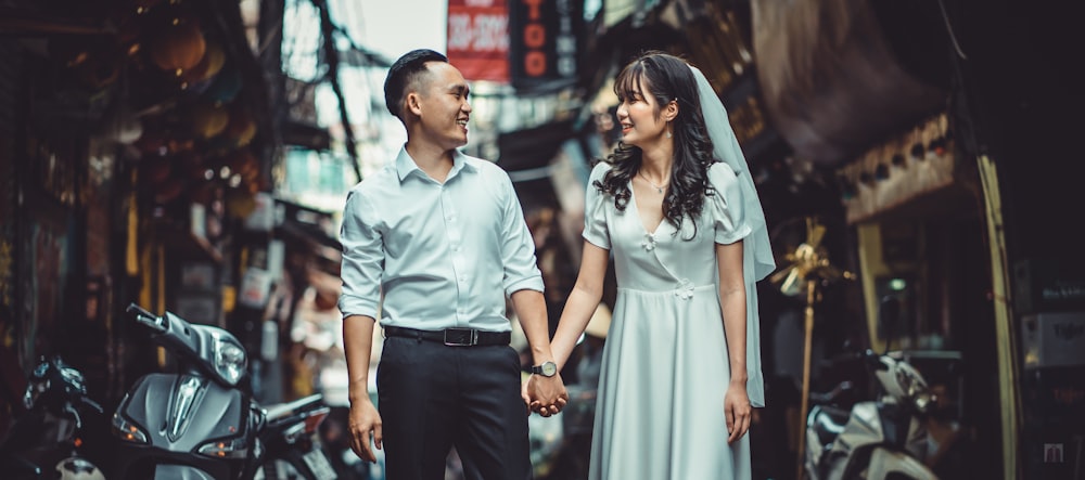 homme en chemise boutonnée bleue et femme en robe blanche