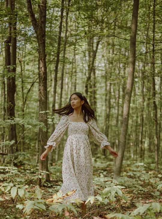 woman in white and black floral dress standing in forest during daytime in Tiny Canada