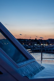 Evening scene of a 16-meter yacht illuminated with soft lights against a sunset backdrop