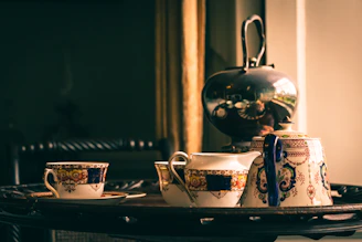 A beautifully crafted Moroccan handmade teapot and tray set displayed on an elegant beige background with subtle green and golden accents.