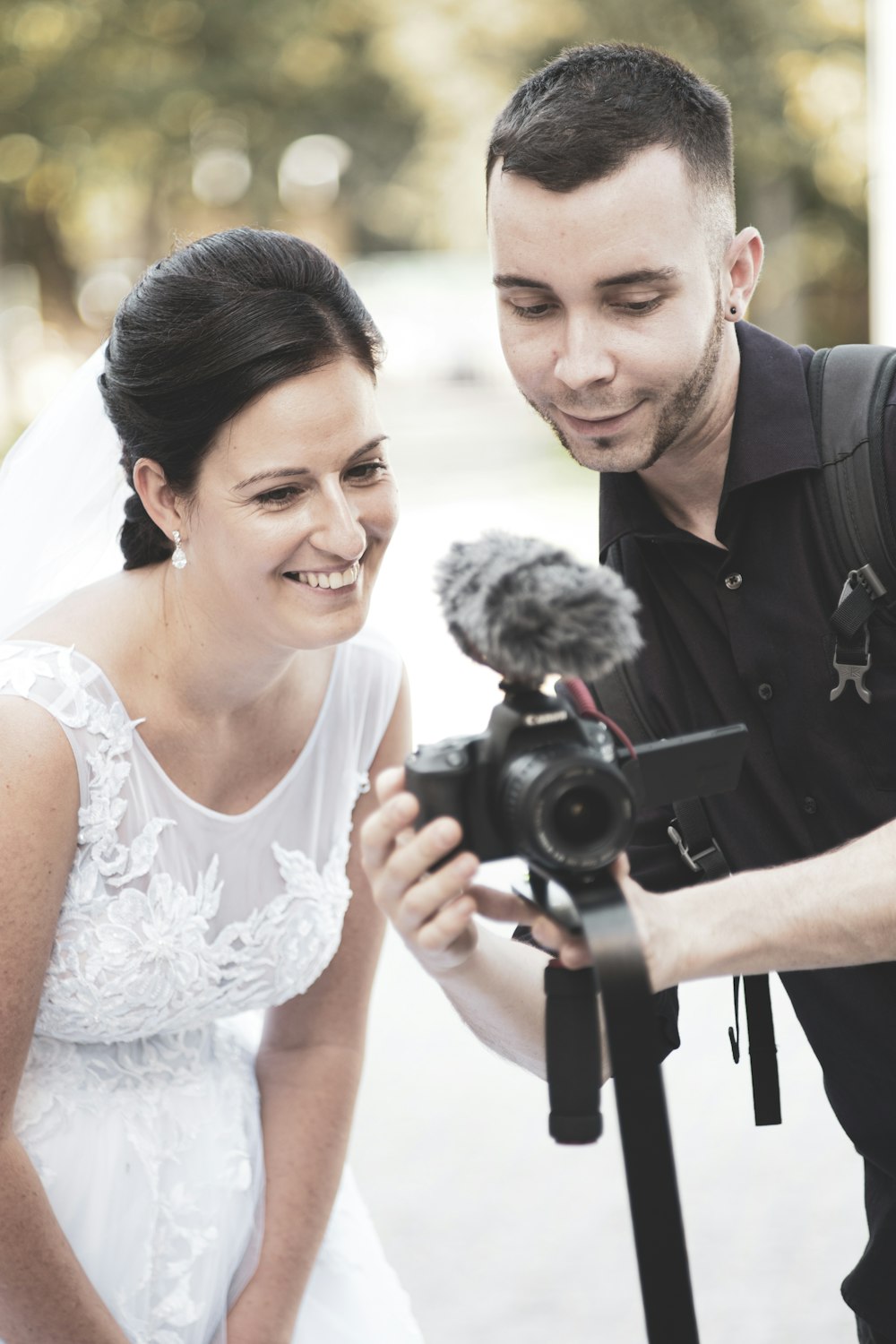 man in black suit holding black dslr camera