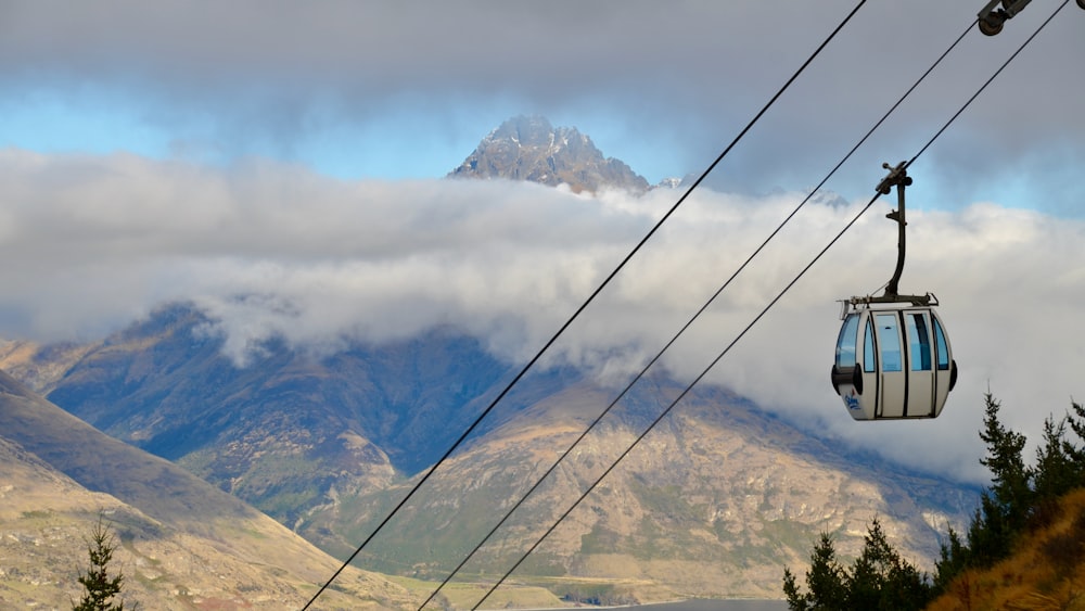 fil de câble noir au-dessus des arbres verts et des montagnes pendant la journée