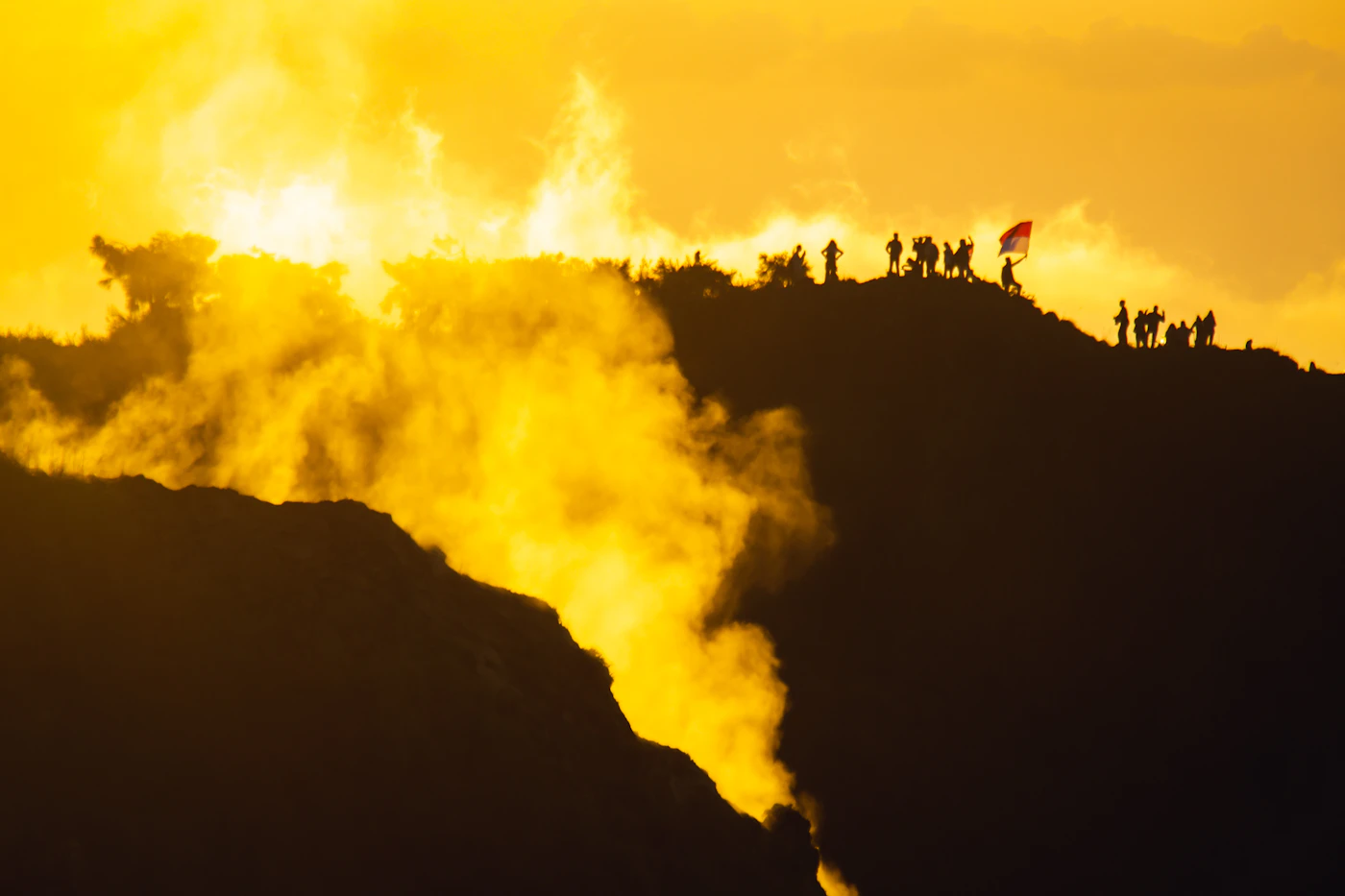 Hikers silhouetted at sunrise on Mount Batur
