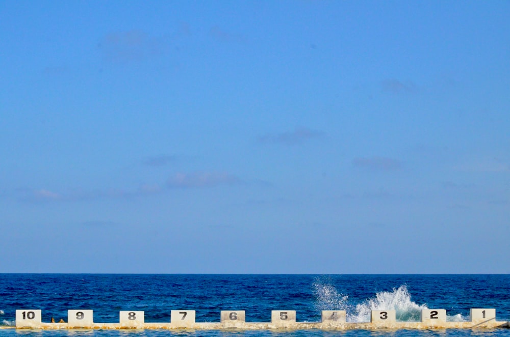 white wooden fence on beach during daytime