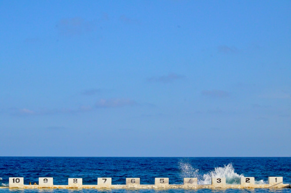 recinzione di legno bianca sulla spiaggia durante il giorno