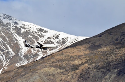 Aerial view of an airplane flying over mountains.