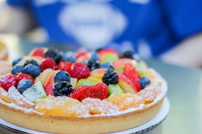 A vibrant display of passion fruit and strawberry tarts in a bakery setting.